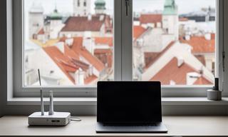 Modern Tallinn apartment desk with fast internet equipment and a view of historic rooftops