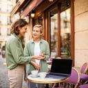 Ermal Theyamathy speaking with a remote worker beside a European café